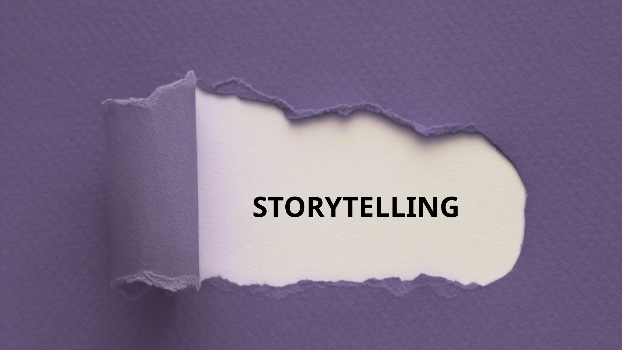 Detail of a purple notebook cover with a section torn to reveal the word "storytelling" on the first page