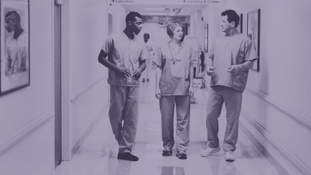 hospital workers walking down a hall and conversing