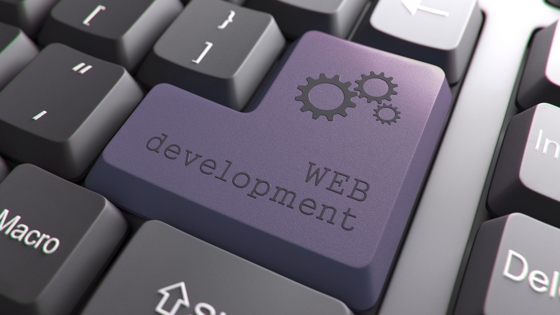 A computer keyboard with the words "web development" written o n the enter key