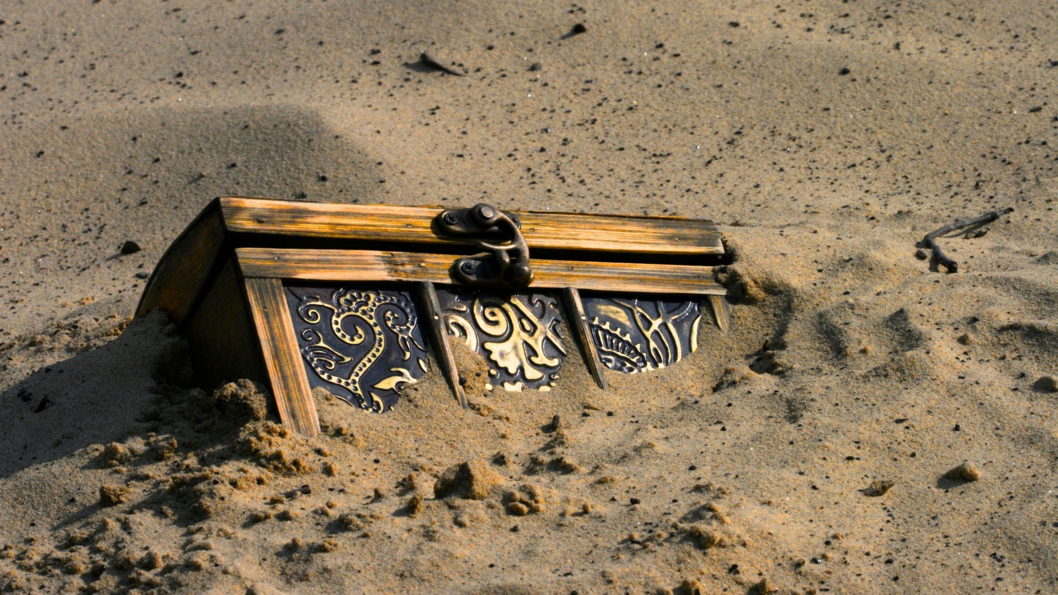 A treasure chest partially buried in the sand